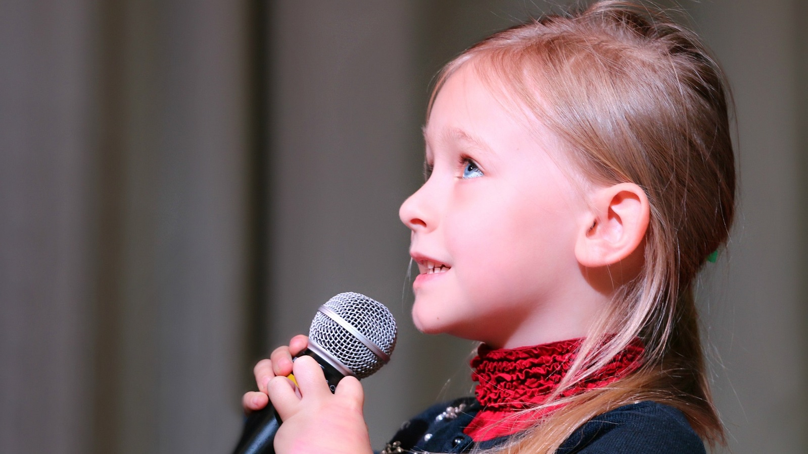 Ein junges Mädchen hält eine Rede über ein Mikrofon